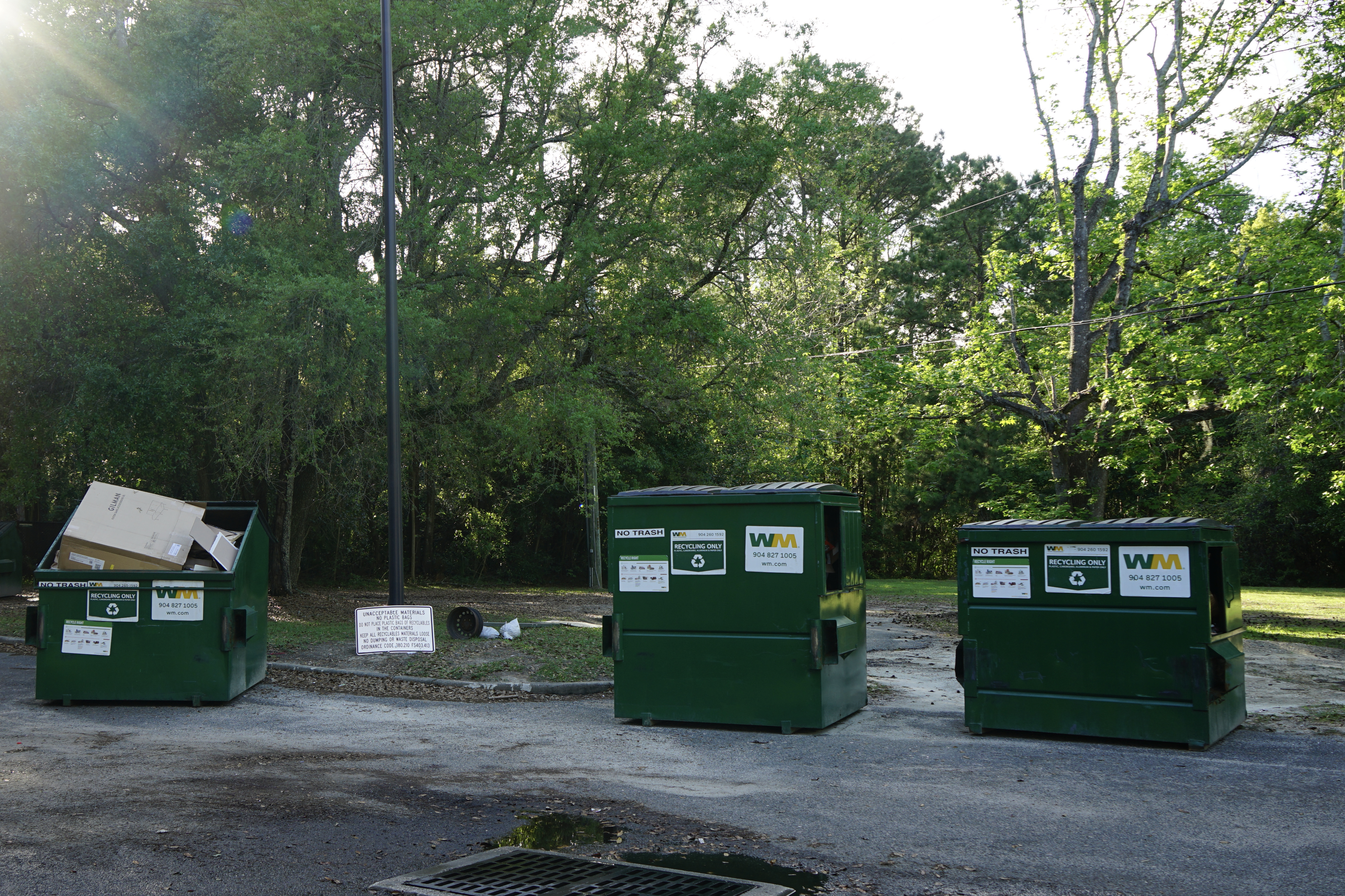 Three big dumpsters located in one of the city parks