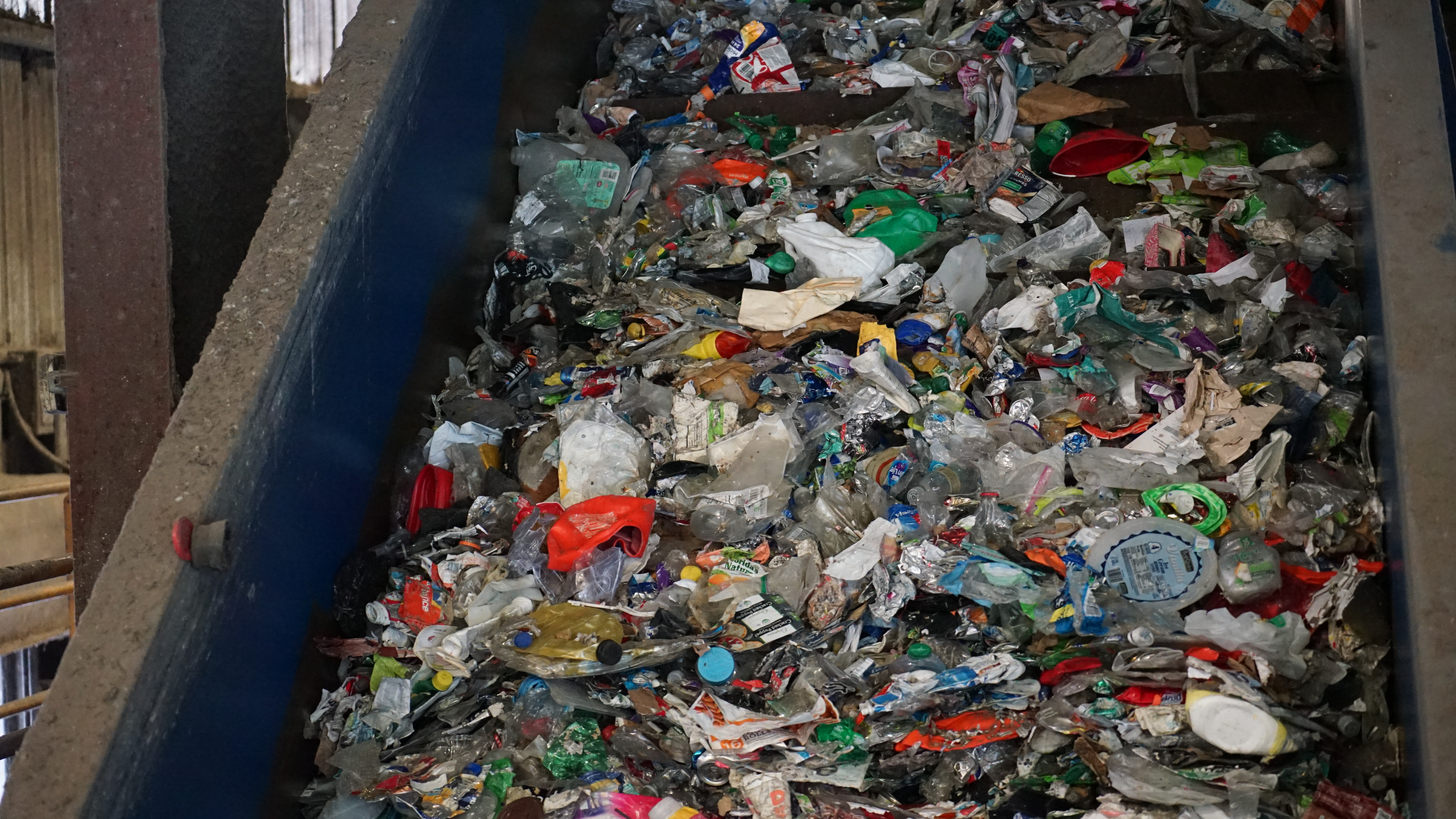 Plastics get piled on a conveyor belt at the recycling center
